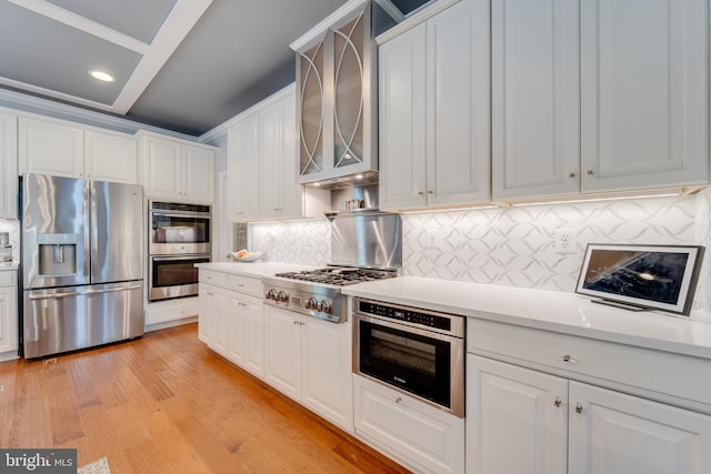 kitchen with white cabinets, light countertops, appliances with stainless steel finishes, and tasteful backsplash
