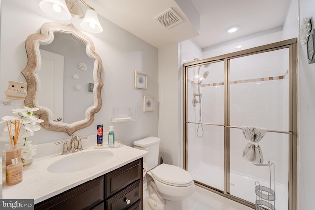 bathroom featuring a stall shower, toilet, vanity, and visible vents