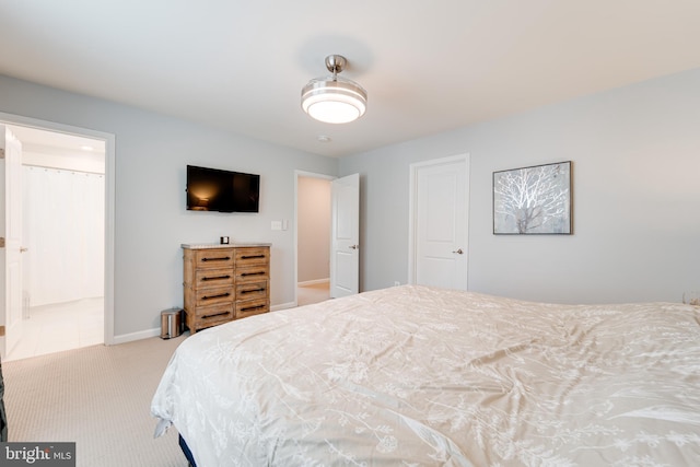 bedroom with connected bathroom, carpet floors, and baseboards