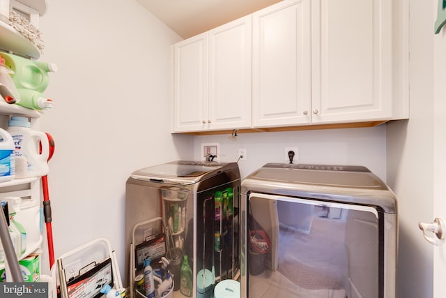 washroom featuring cabinet space and washer and clothes dryer