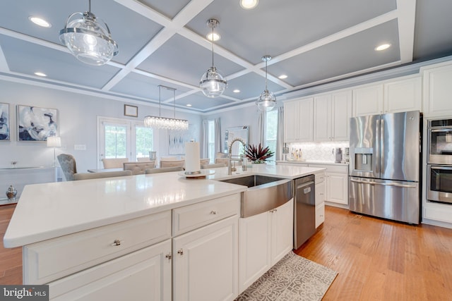 kitchen with coffered ceiling, a sink, white cabinetry, decorative backsplash, and stainless steel appliances