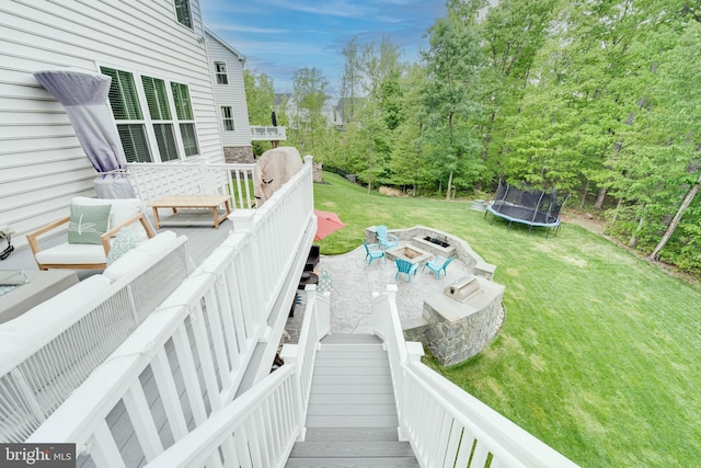 exterior space featuring a yard, an outdoor living space with a fire pit, and a trampoline