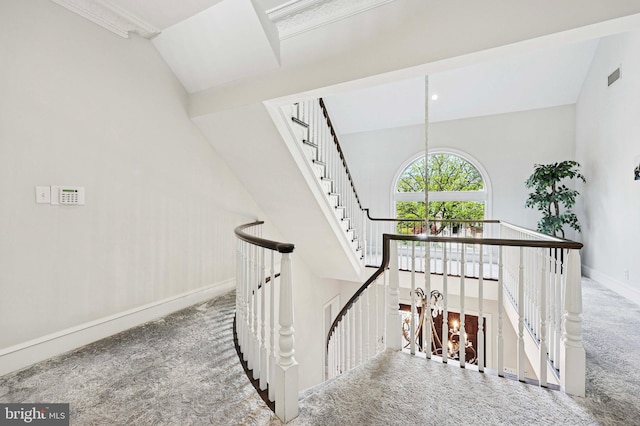 staircase featuring carpet floors, baseboards, visible vents, and an inviting chandelier