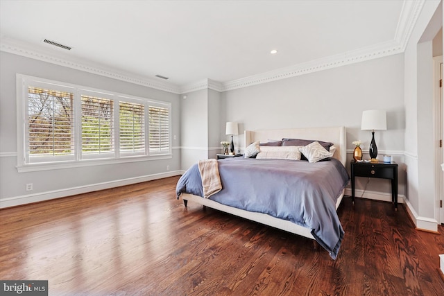 bedroom with visible vents, ornamental molding, baseboards, and wood finished floors