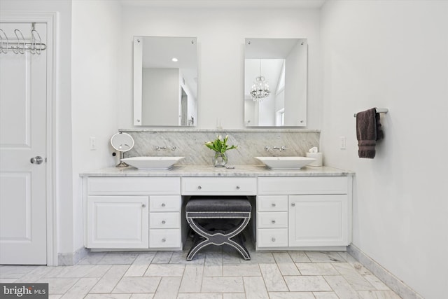 bathroom with double vanity, a sink, and tasteful backsplash