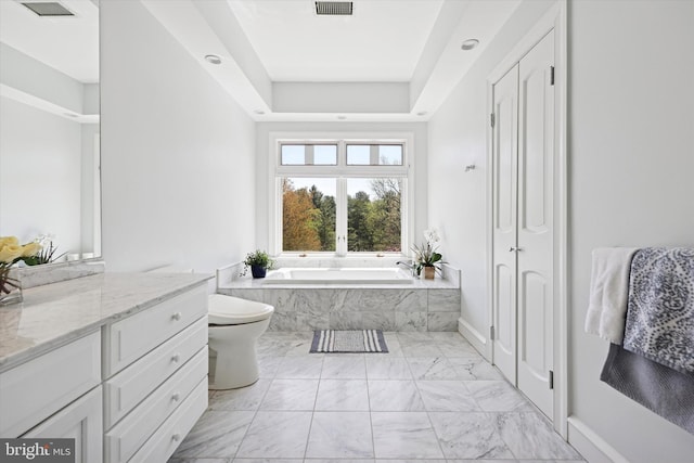 bathroom featuring vanity, marble finish floor, a tray ceiling, visible vents, and a garden tub