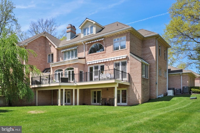 back of house featuring french doors, central AC unit, a yard, and brick siding
