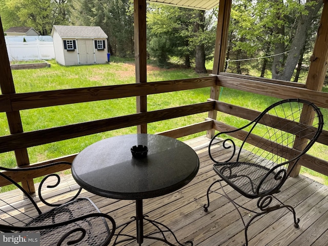 wooden deck with fence, a lawn, a storage unit, and an outdoor structure