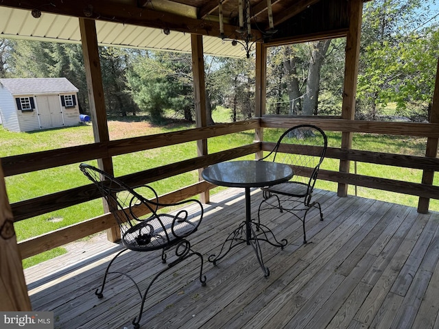 wooden terrace with an outdoor structure, a yard, and a shed