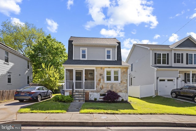 view of front of property with concrete driveway, a garage, stone siding, and a front lawn