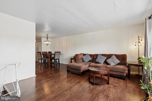 living area featuring baseboards, wood finished floors, and a chandelier