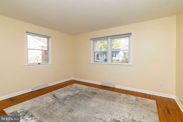 unfurnished room with baseboards, visible vents, and a healthy amount of sunlight