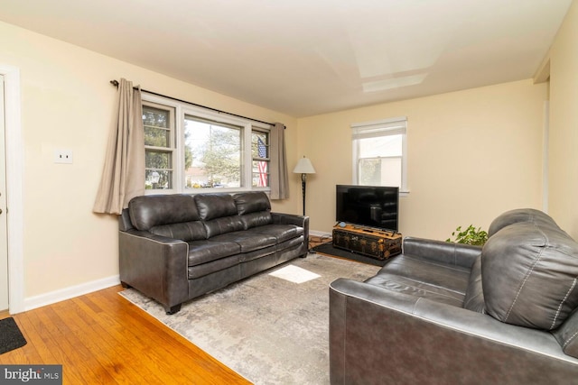 living area with wood-type flooring and baseboards