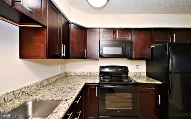 90 Catherine Ct, Levittown, PA 19057 - kitchen with light stone counters, a textured ceiling, dark brown cabinetry, and black appliances