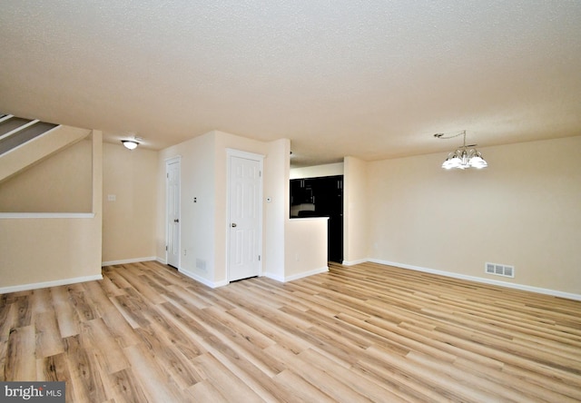 90 Catherine Ct, Levittown, PA 19057 - bonus room with visible vents, an inviting chandelier, baseboards, a textured ceiling, and light wood-style flooring