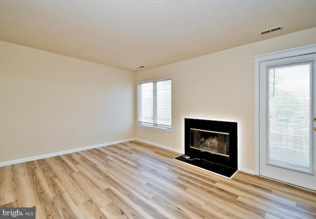 90 Catherine Ct, Levittown, PA 19057 - unfurnished living room with visible vents, a fireplace with flush hearth, baseboards, and wood finished floors