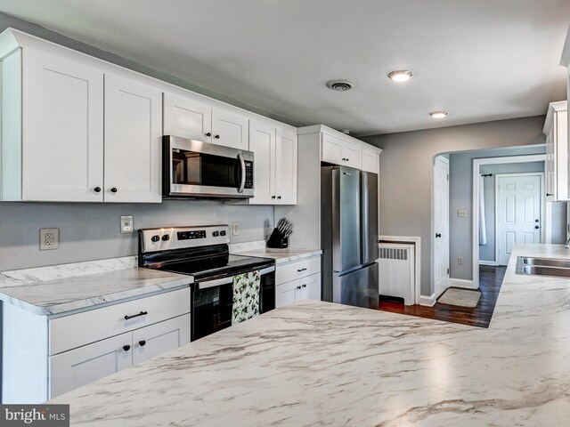 724 Webb St, Aberdeen, MD 21001 - kitchen with appliances with stainless steel finishes, radiator, white cabinets, dark wood finished floors, and light stone countertops