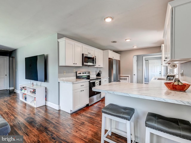724 Webb St, Aberdeen, MD 21001 - kitchen featuring stainless steel appliances, dark wood finished floors, a peninsula, light countertops, and white cabinets