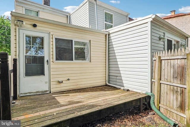 511 9th St, New Castle, DE 19720 - back of property featuring a chimney, a wooden deck, and fence