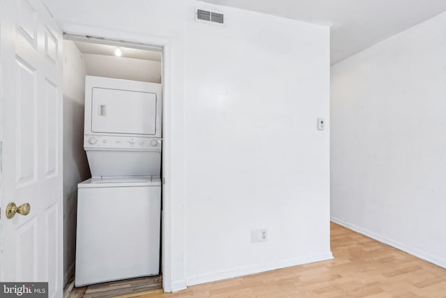511 9th St, New Castle, DE 19720 - washroom with stacked washer / dryer, wood finished floors, laundry area, visible vents, and baseboards