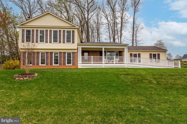 back of property featuring brick siding and a yard