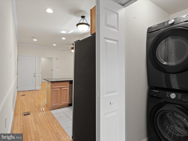 clothes washing area with stacked washing maching and dryer, laundry area, light wood finished floors, visible vents, and recessed lighting