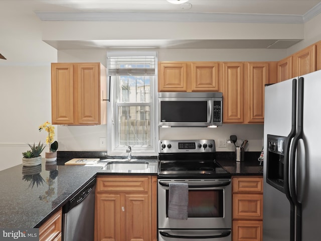 kitchen with stainless steel appliances, a sink, dark stone counters, and crown molding