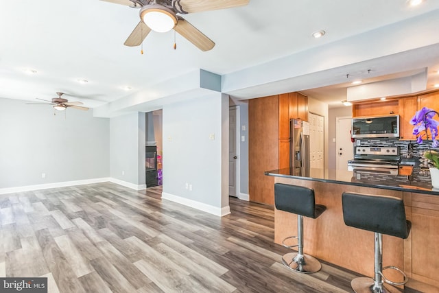 128 Granite Hill Ct, Langhorne, PA 19047 - kitchen featuring dark countertops, appliances with stainless steel finishes, ceiling fan, and wood finished floors