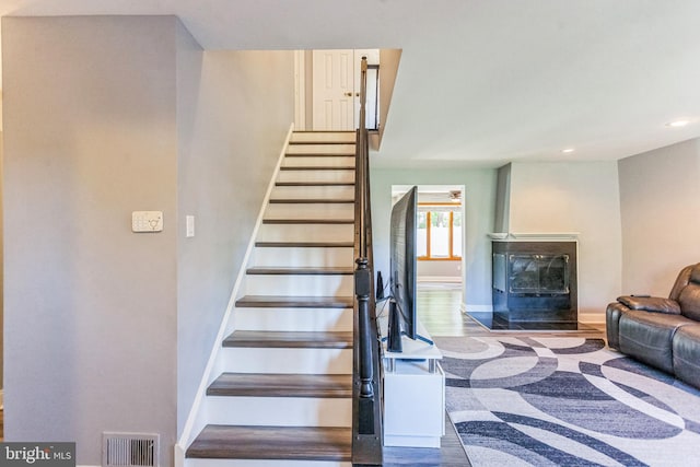 128 Granite Hill Ct, Langhorne, PA 19047 - stairs with visible vents, a glass covered fireplace, wood finished floors, baseboards, and recessed lighting