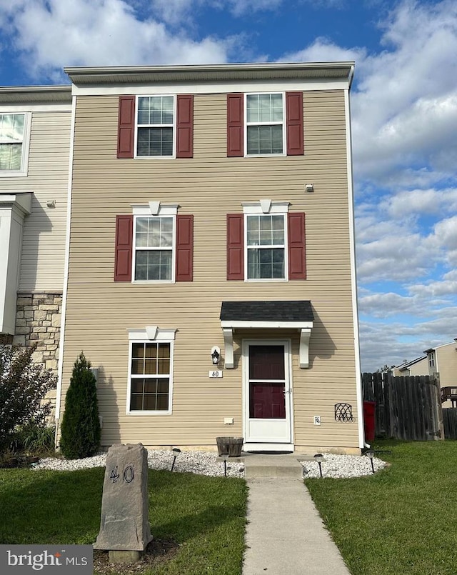 multi unit property featuring fence and a front lawn