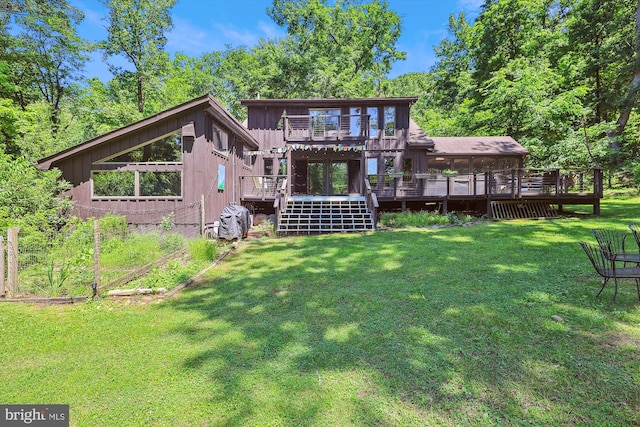 rear view of house featuring board and batten siding, a yard, and a deck