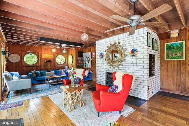 living room featuring wooden walls, ceiling fan, beam ceiling, and hardwood / wood-style floors