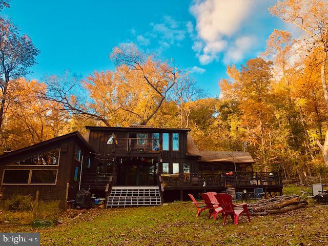 rear view of house with a lawn and a wooden deck