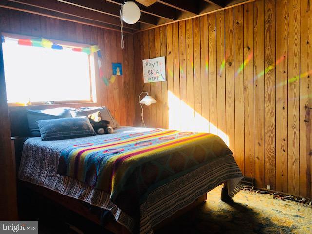 bedroom featuring wooden walls