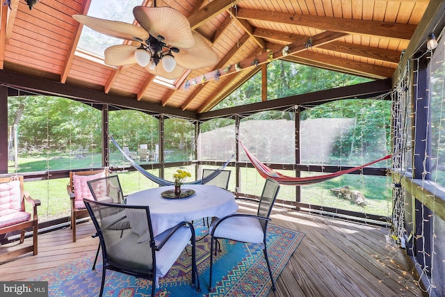 sunroom with outdoor dining area, a ceiling fan, and a healthy amount of sunlight