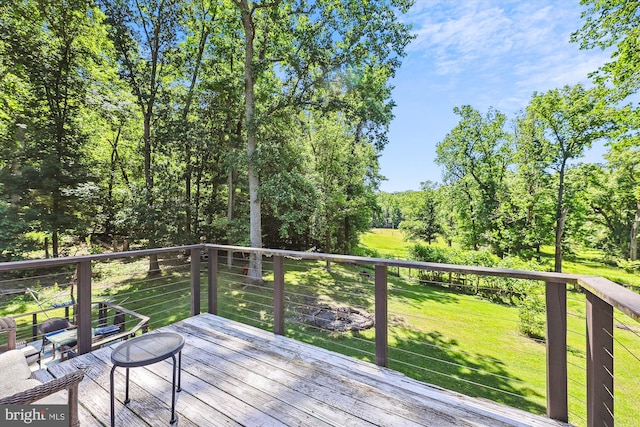 wooden deck featuring a lawn