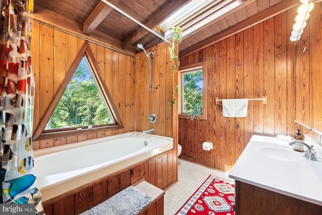 bathroom featuring beam ceiling, wood walls, wooden ceiling, and a healthy amount of sunlight