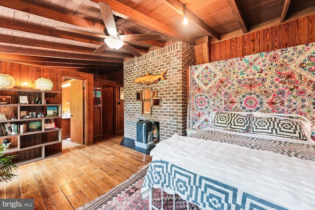 bedroom with wood walls, wooden ceiling, beam ceiling, and hardwood / wood-style flooring