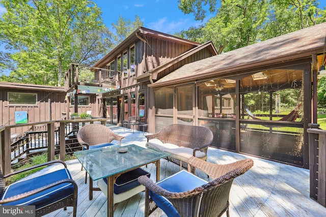 wooden deck featuring outdoor dining space and a sunroom