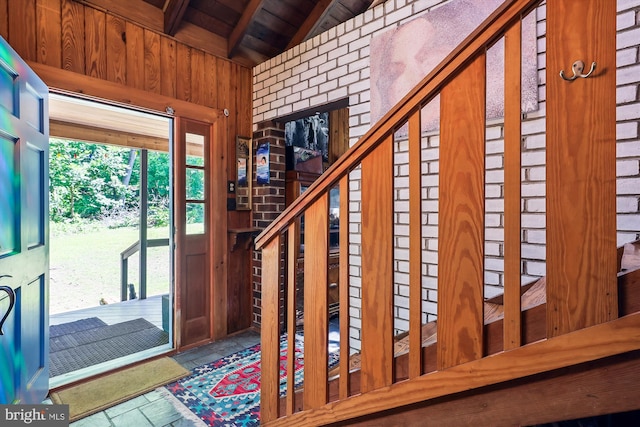 entrance foyer with wooden ceiling, vaulted ceiling with beams, and wood walls