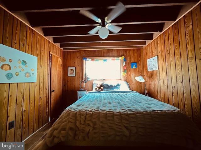 bedroom featuring wood walls
