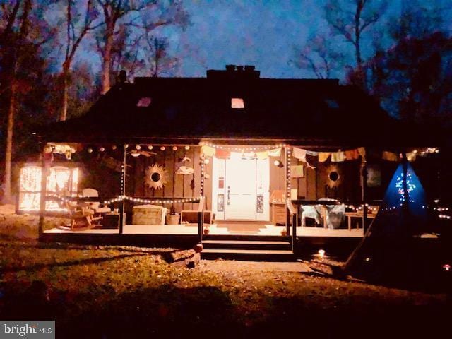 back of house at night featuring a patio area