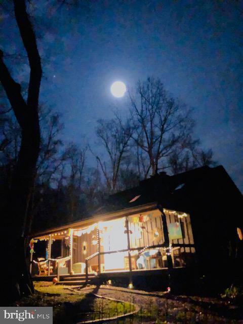 property exterior at twilight with a sunroom