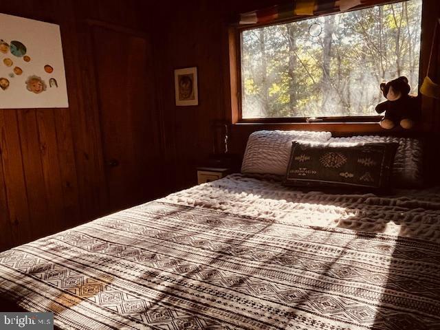 bedroom featuring wood walls