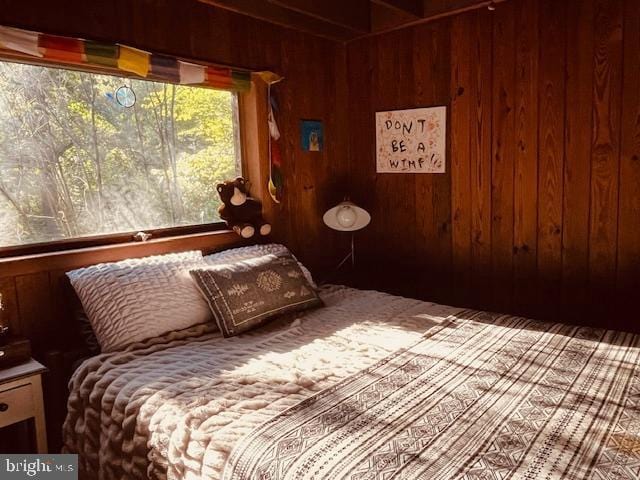 bedroom featuring wood walls