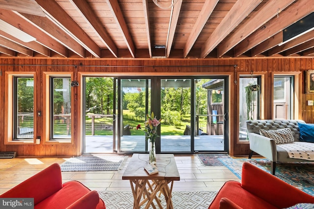 entryway with a healthy amount of sunlight, wood walls, and beam ceiling