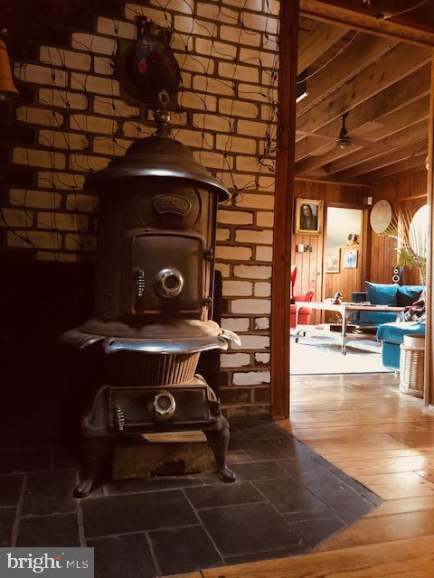 details featuring wood finished floors, beam ceiling, and wooden walls