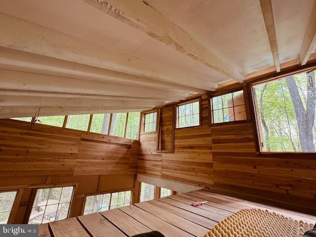unfurnished sunroom with beam ceiling