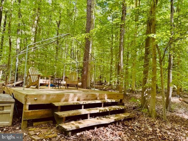 exterior space with a view of trees and a deck