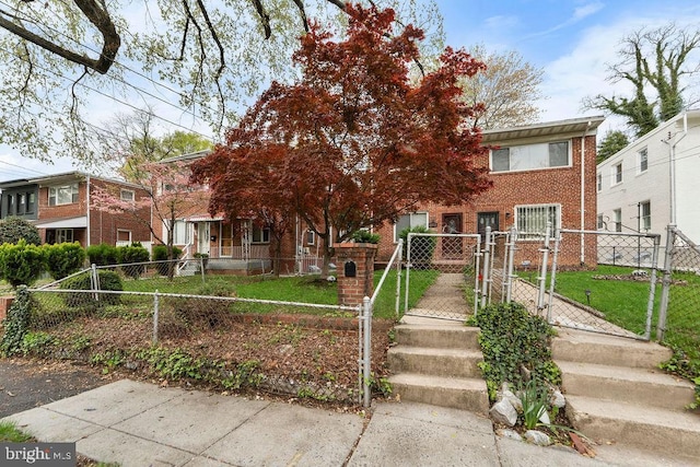 obstructed view of property featuring a front yard, a gate, brick siding, and a fenced front yard